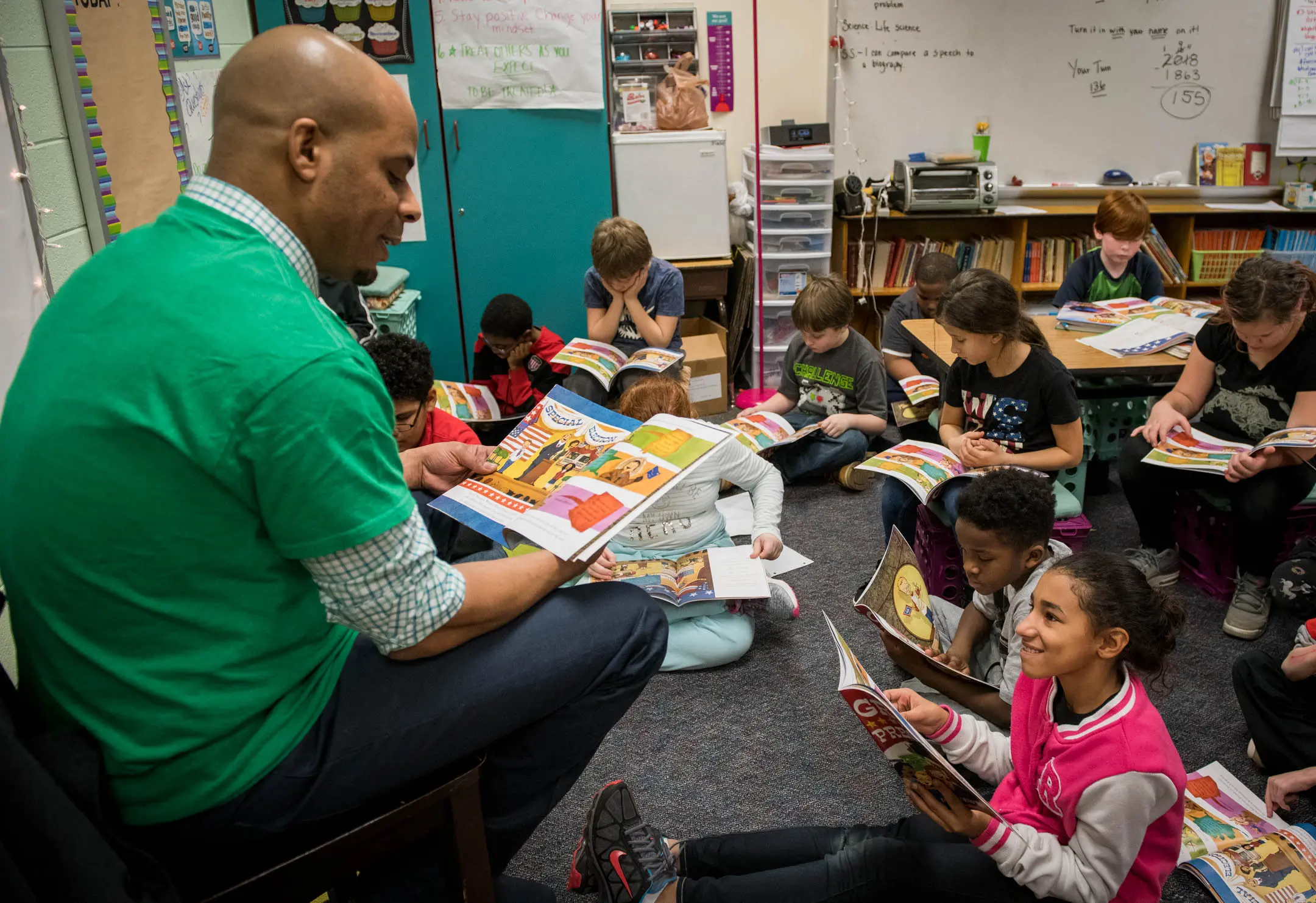 Man reading a book in a Kentucky classroom to children